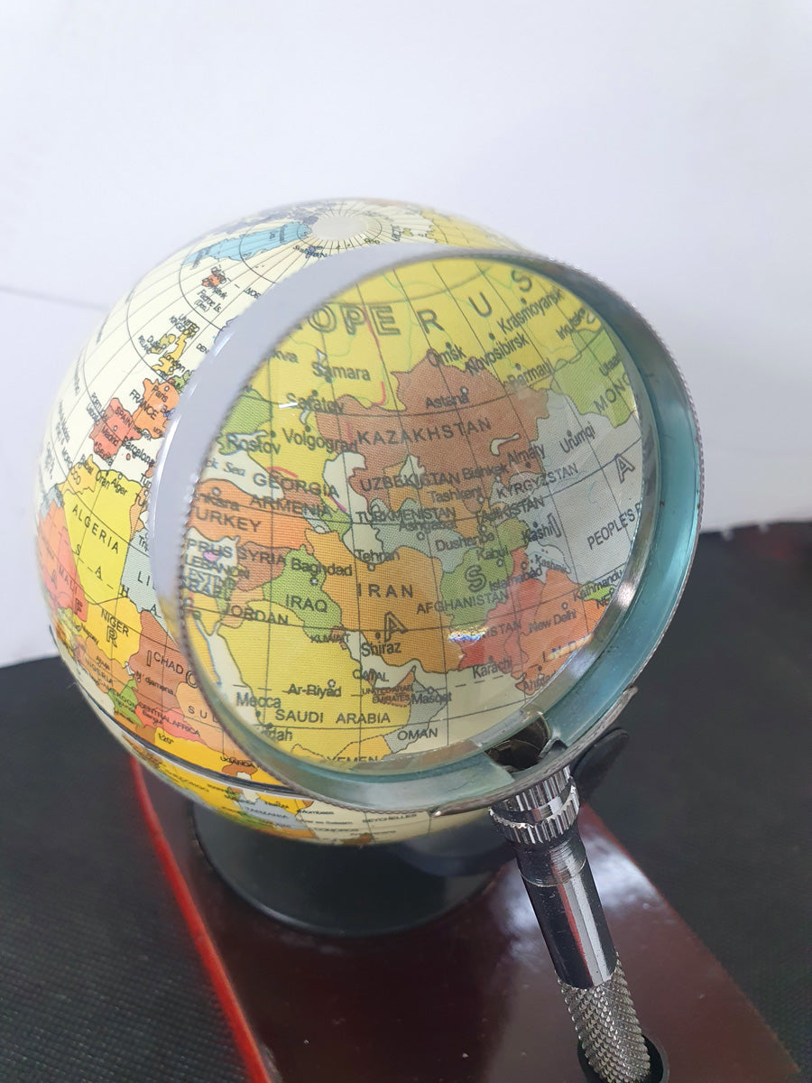 Desktop globe with wooden base and magnifying glass